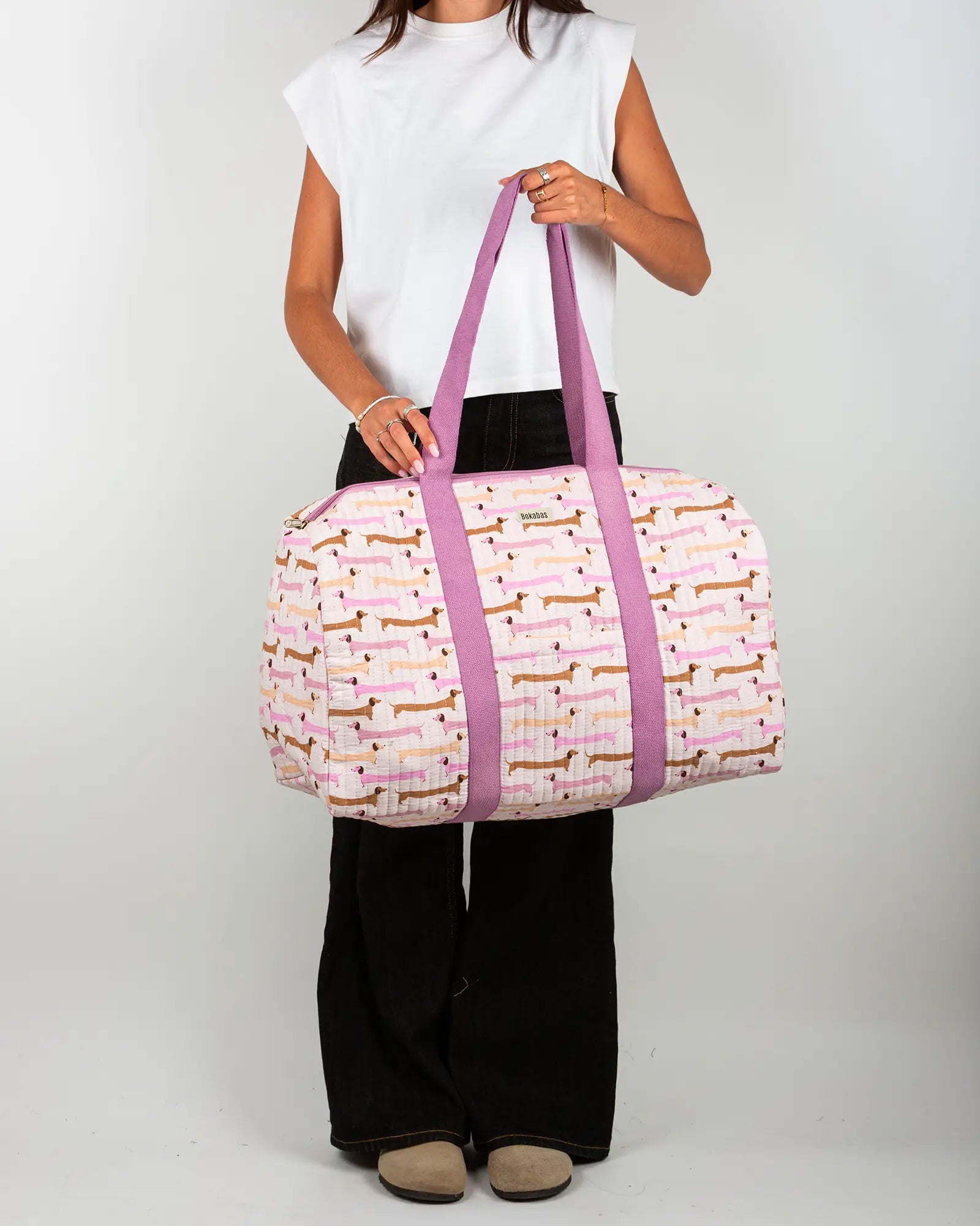 Sac week-end matelassé Bokabas, imprimé Saucisse chien teckel rose et violet, porté