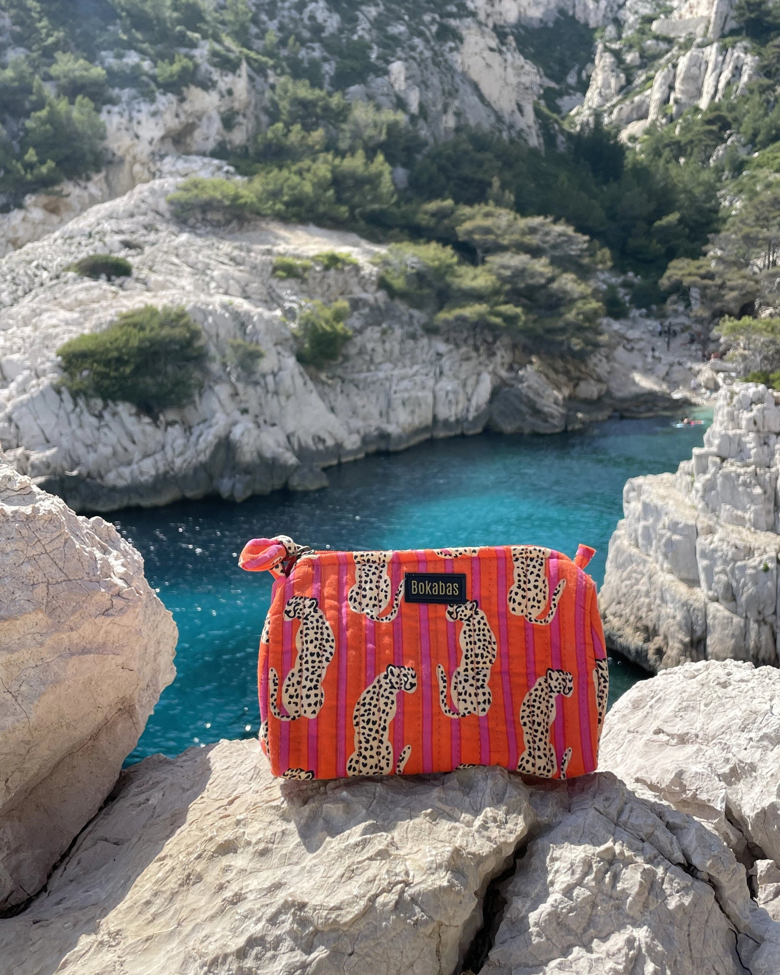 Trousse de toilette matelassée Bokabas, imprimé Guépard, au bord d'une eau turquoise