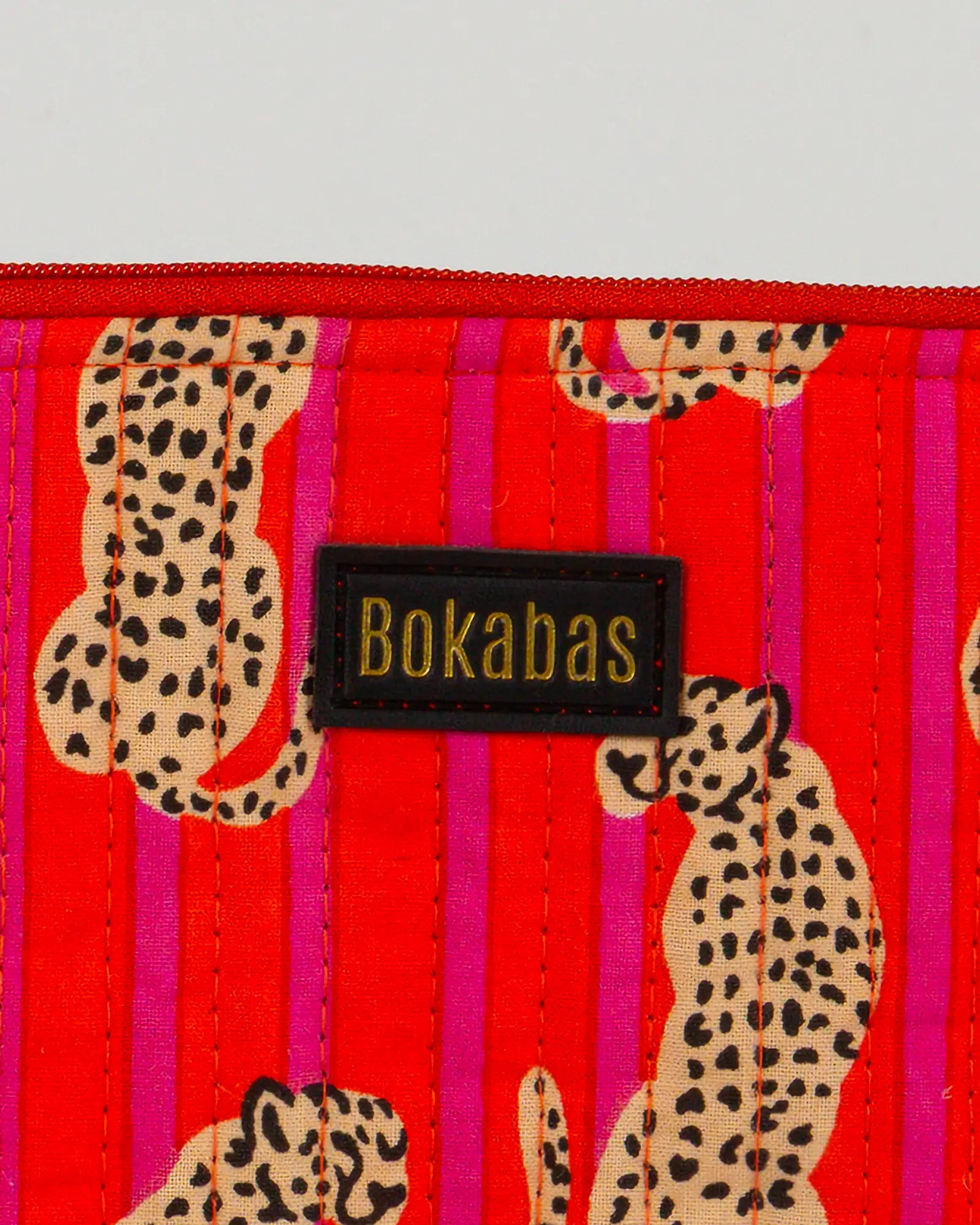 Pochette matelassée à froufrous Bokabas, imprimé Guépard rayé orange et rose, zoom sur la matière