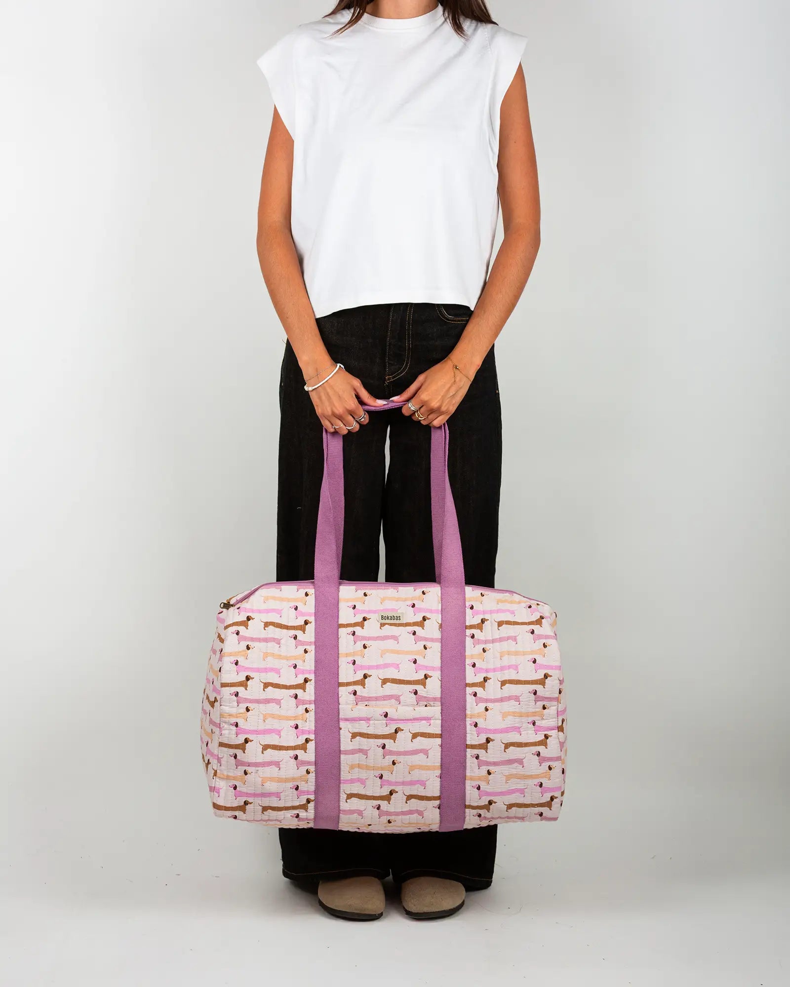 Sac week-end matelassé Bokabas, imprimé Saucisse chien teckel rose et violet, porté