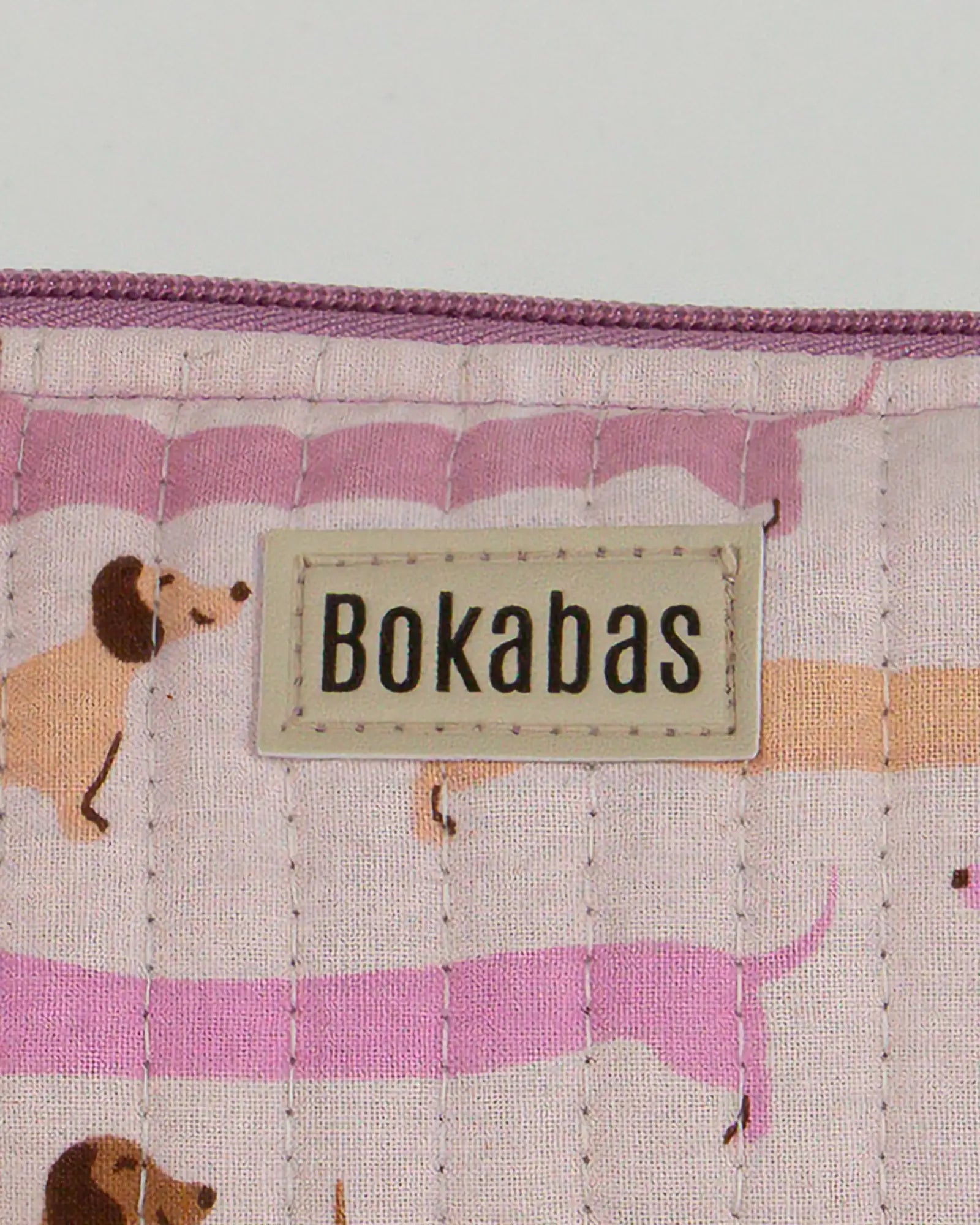 Trousse à crayons scolaire matelassée Bokabas, imprimé Saucisse chien teckel rose et violet, zoom sur la matière
