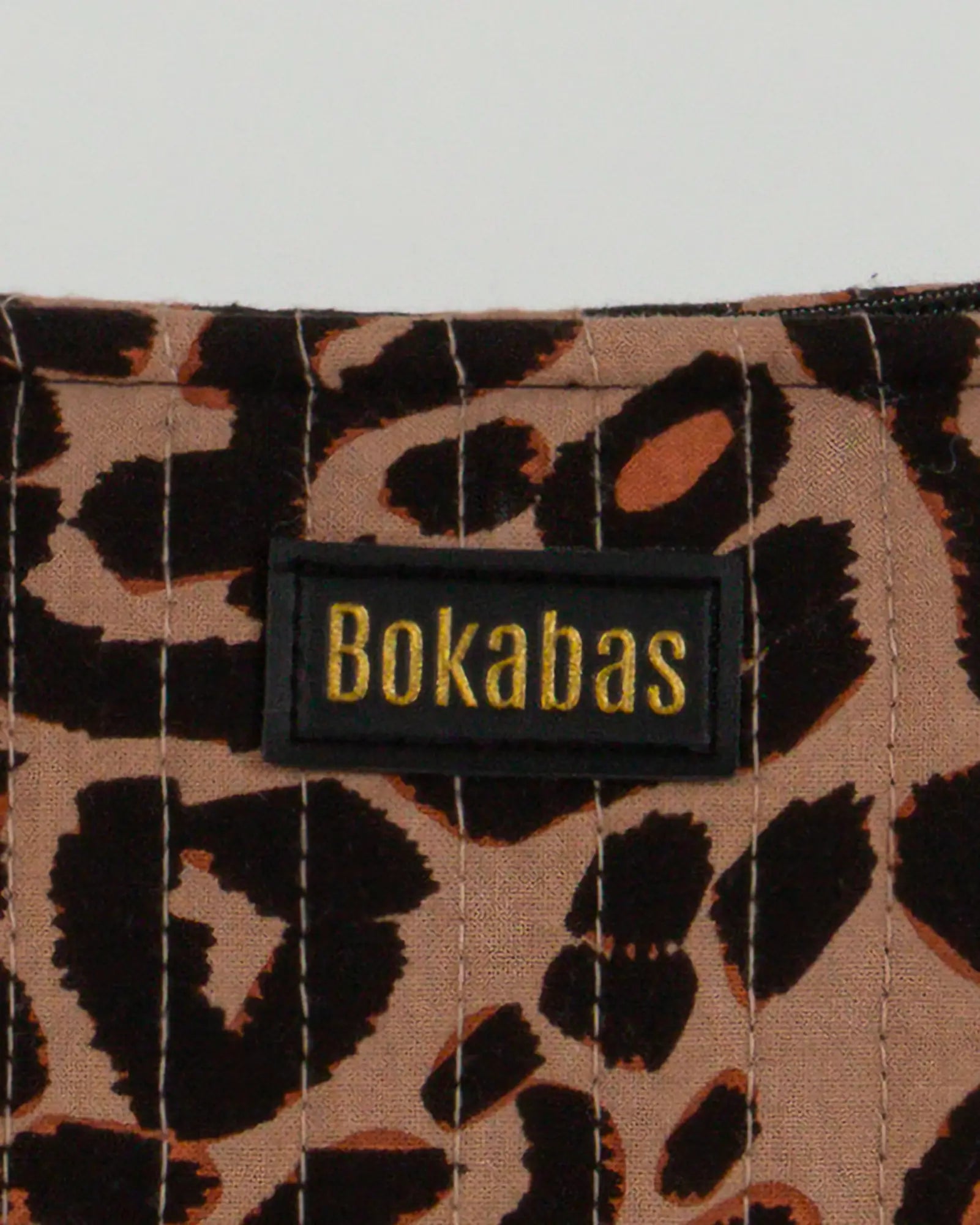 Trousse de toilette matelassée en coton Bokabas, imprimé léopard noir et marron, zoom sur la matière