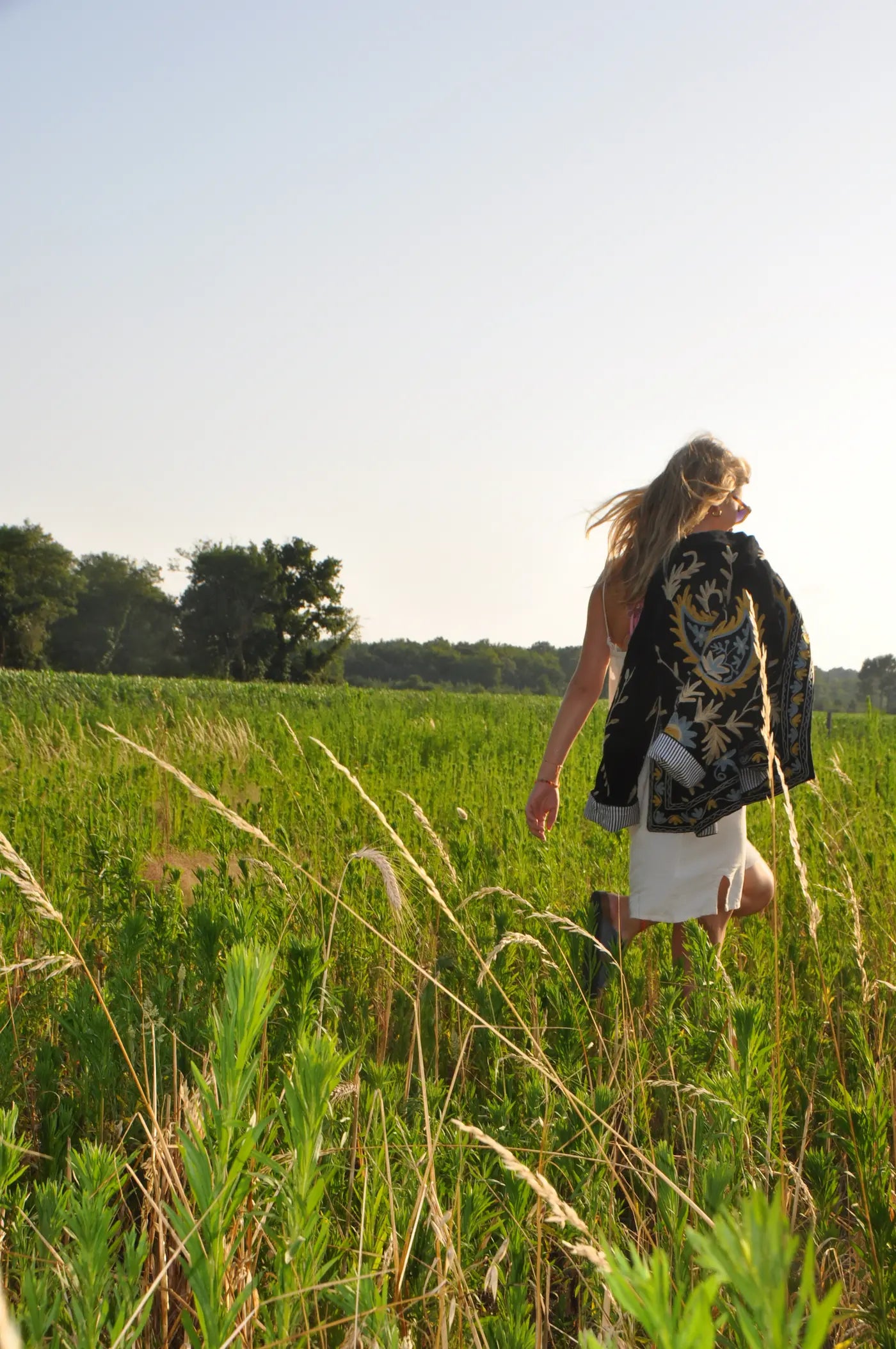 Veste noire brodée fleurie portée en marchant dans une prairie – Bokabas