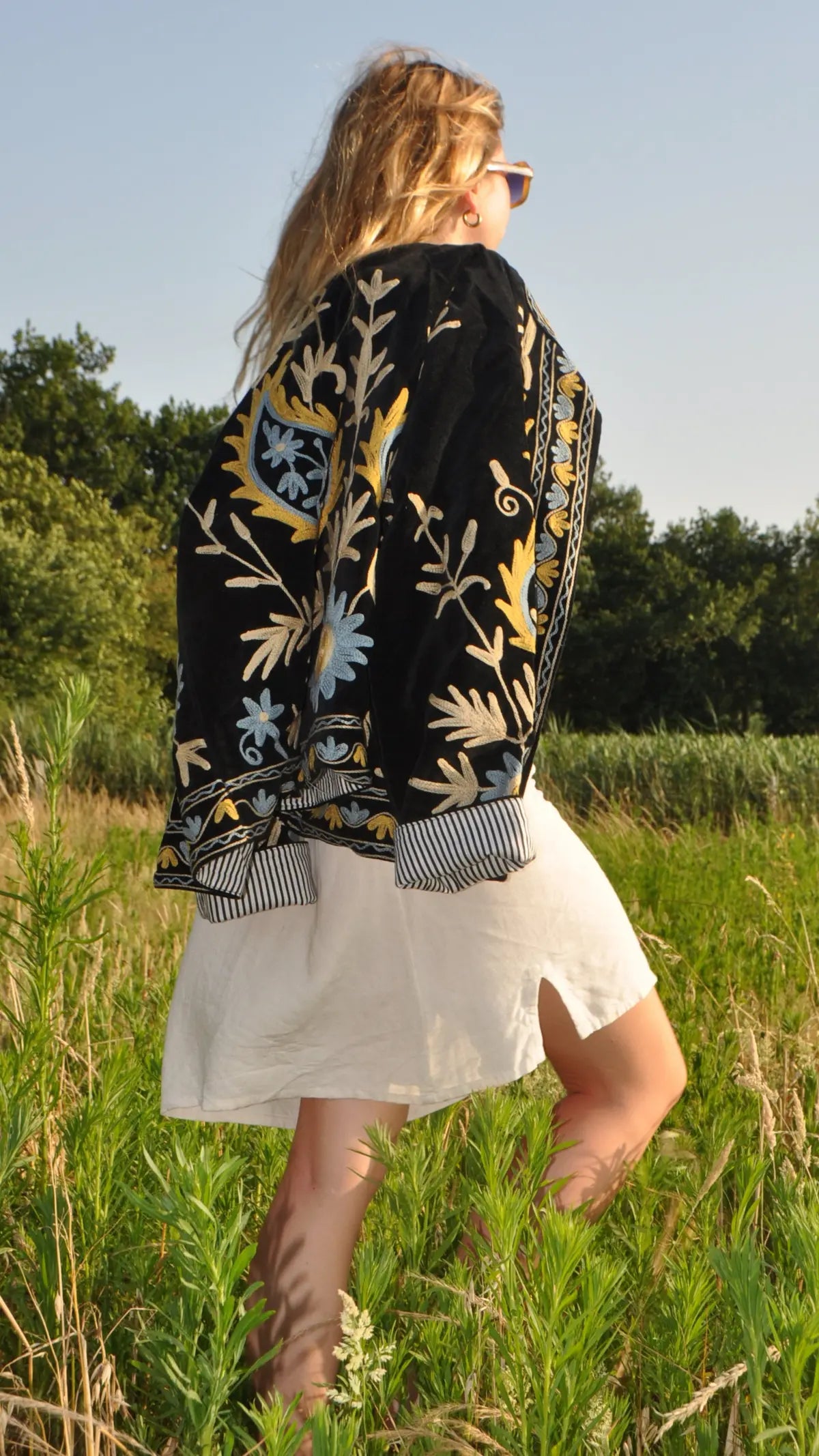 Veste noire brodée fleurie portée en marchant de profil – Bokabas